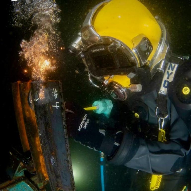 Taucher führt Unterwasser-Brennarbeiten mit Brennelektroden durch